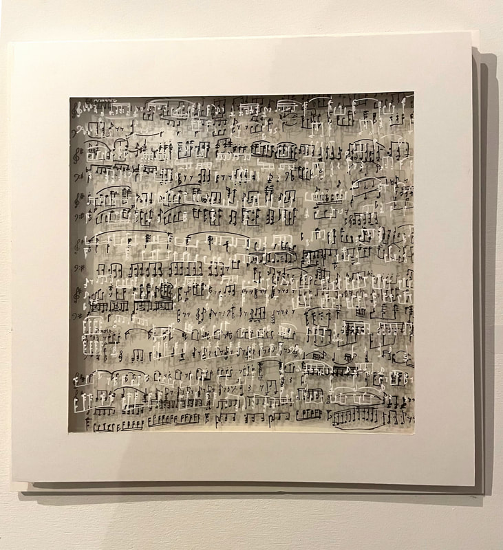 Artwork comprised of  varying layers of transparent mylar covered in black and white musical notes, casting shadows on a white background